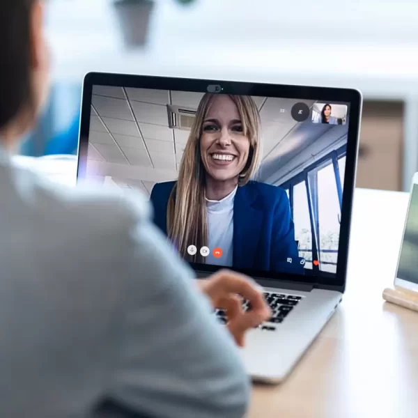 Commercial interior designer conducting a virtual video consultation with a client using a laptop, discussing commercial fit-out and interior design projects remotely.