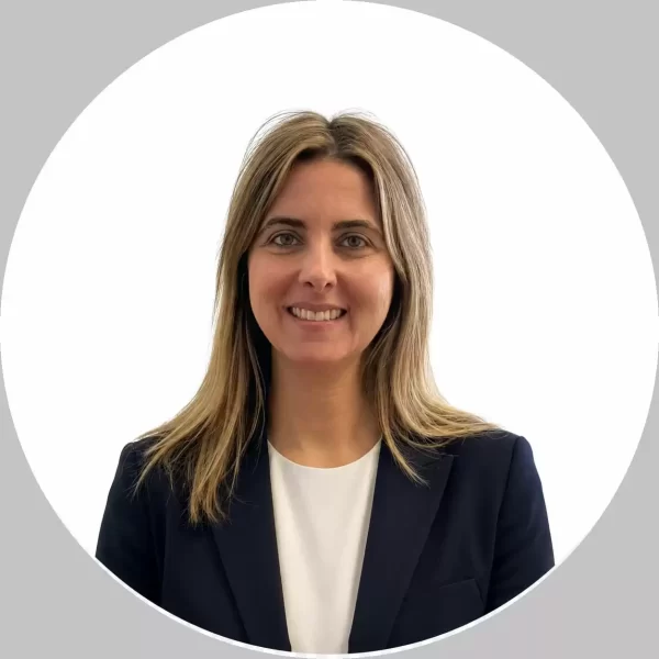 Professional headshot of a commercial interior designer from Associated Design Studio, smiling and wearing a navy blazer against a clean white background.